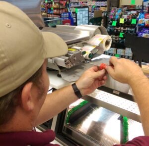 Scale tech Technician servicing a commercial scale and label printer in a grocery store