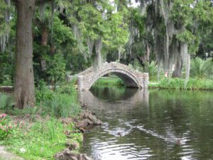Stone bridge over calm, tree-lined water. Stone bridge over calm, tree-lined water.