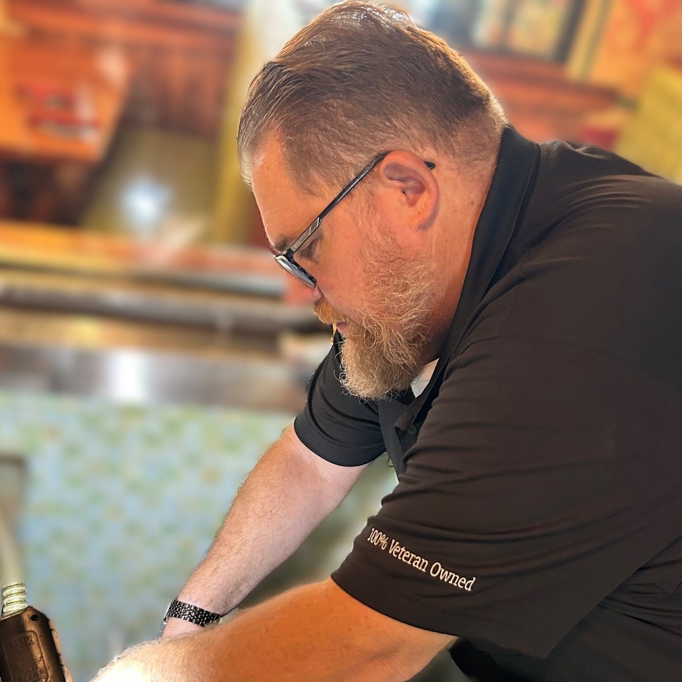 Gulf Coast Equip Care technician working on commercial kitchen equipment at a local restaurant, wearing a 100% Veteran Owned uniform.
